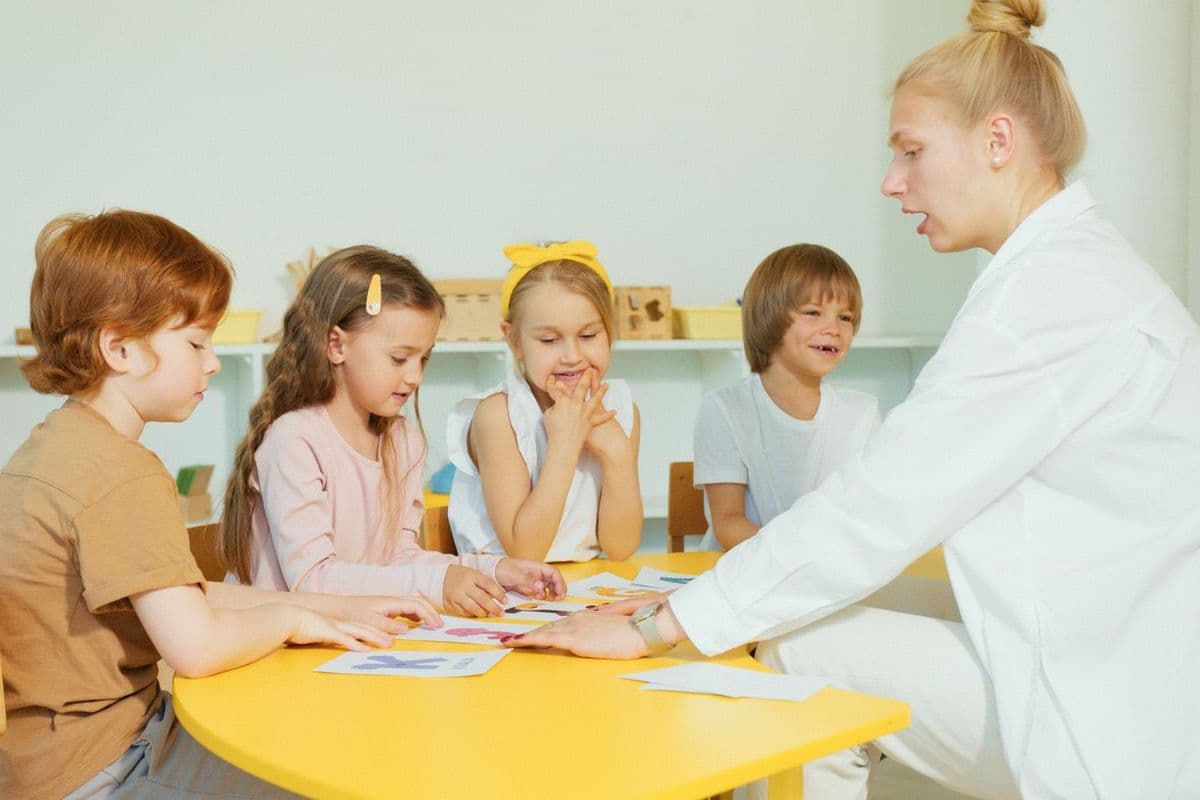 A teacher working with preschoolers at a classroom table